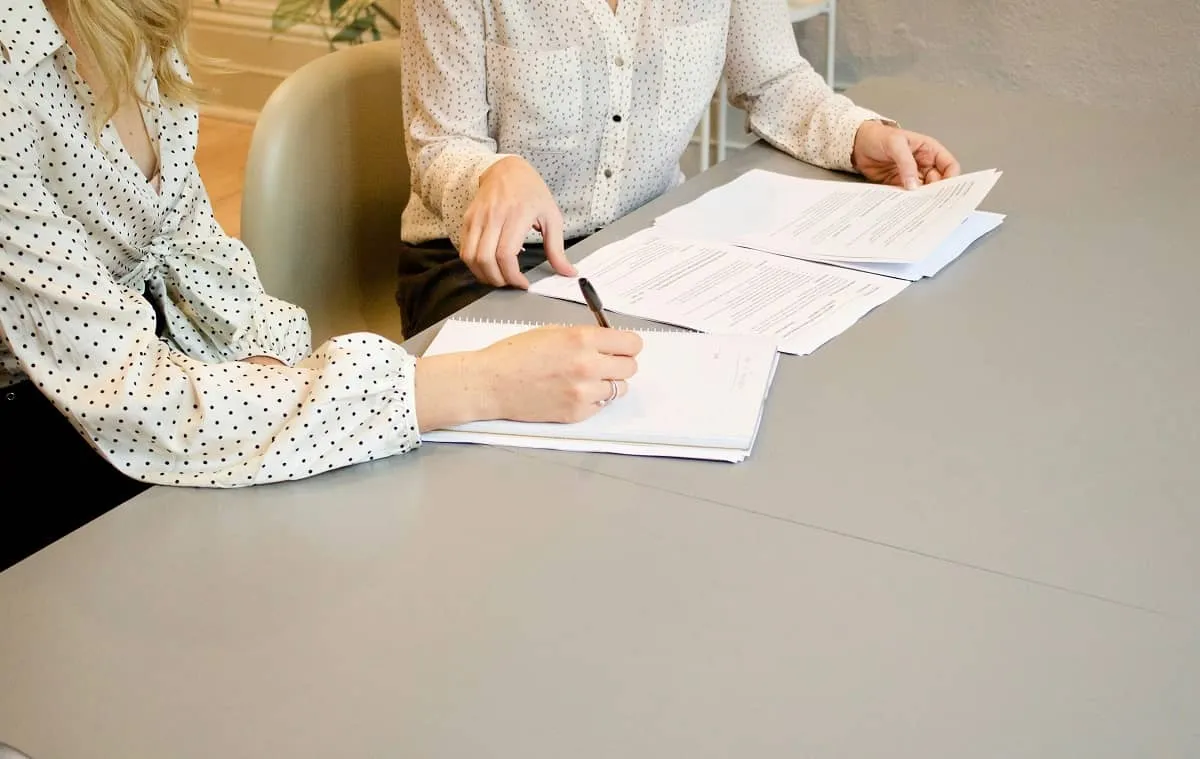 Two people reviewing planning documents and legal paperwork.
